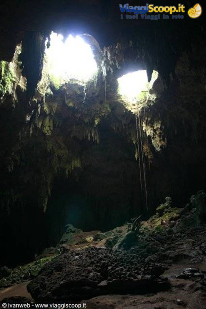 Limestone cave with stalactites and two light openings above