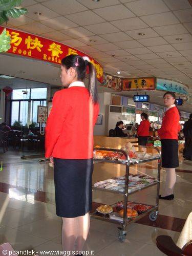 Waitress in red jacket next to a food cart, Chinese restaurant