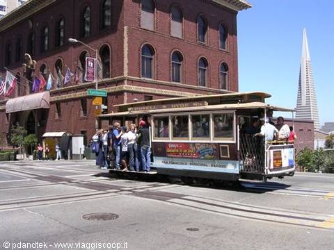 cable car in motion with people hanging from the bars