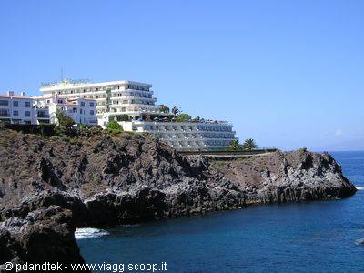 White hotel on volcanic cliffs in Tenerife, blue sky