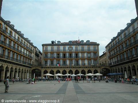 Plaza Nueva in Bilbao: arcaded buildings and white market stalls under grey sky