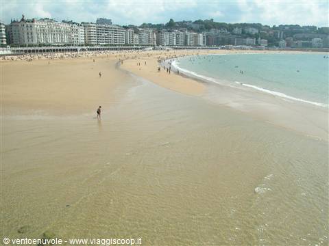 La Concha beach in San Sebastián, bathers on golden sand and white buildings