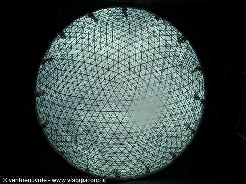 Large circular glass lens with triangular grid glowing from within