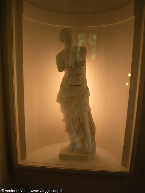 Marble statue in a lit glass case, with drawers carved into the torso