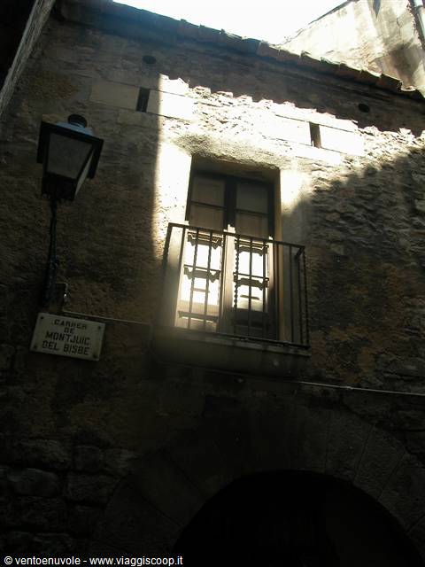 Barcelona, old stone facade with iron balcony and Carrer de Montjuïc del Bisbe sign