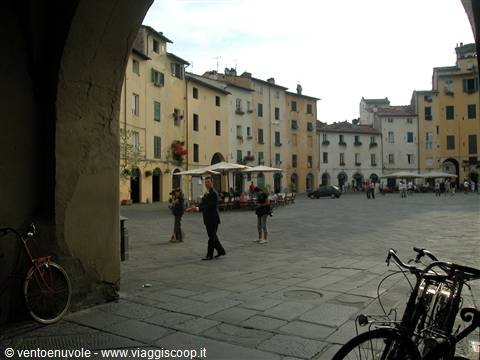 Piazza dell'Anfiteatro in Lucca seen through an arch, bicycles in foreground