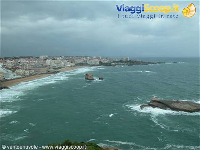 Waves crashing on rocks and buildings along the beach, Biarritz