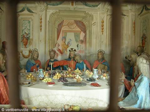 Nativity scene: Last Supper figurines around a laid table, seen through a grate