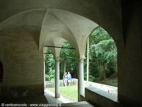 Tourists standing under the vaults and stone columns of a cloister