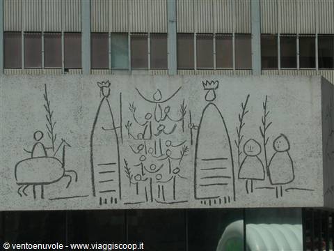 Concrete wall with etched drawing of stylized figures and trees