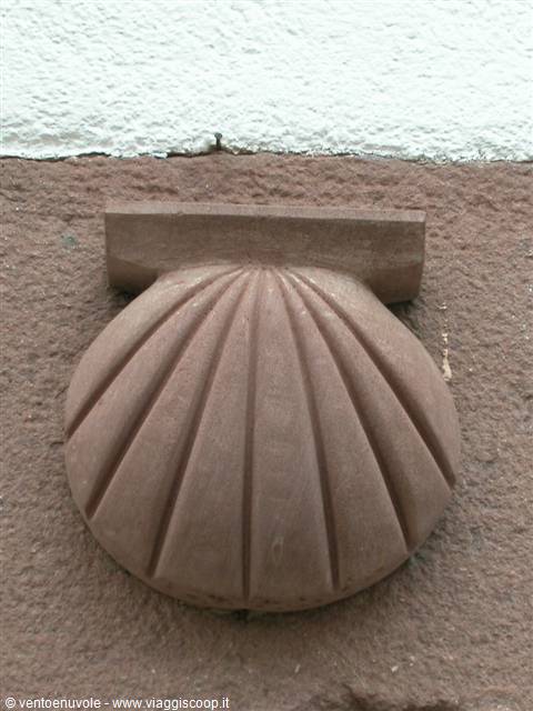 Shell carved in red stone on white plastered wall