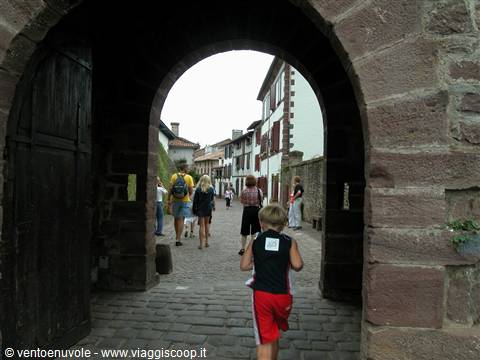 Boy walks through the red sandstone gate of Saint-Jean-Pied-de-Port