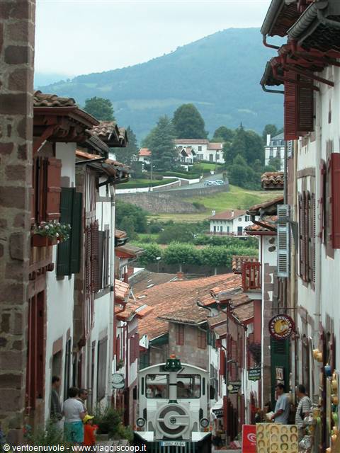 Sloped street with timbered houses and small tourist train in Saint-Jean-Pied-de-Port