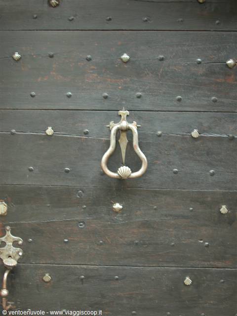Iron knocker on old dark wooden studded door