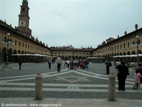 Tourists crossing Vigevano's Piazza Ducale under a grey sky