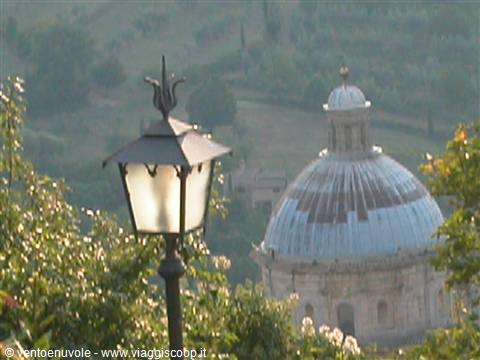 Wrought iron lantern in front of the gray dome of Santa Maria della Consolazione, Todi