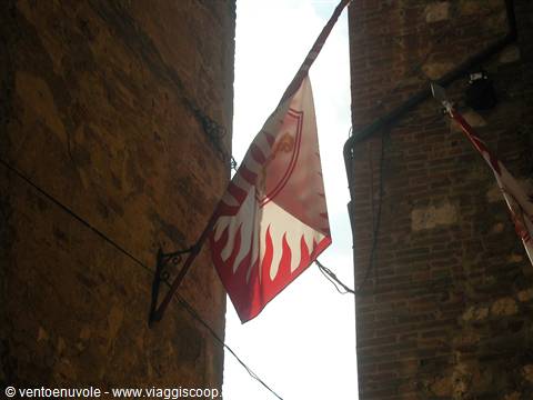 Red flag with white griffin between old brick walls