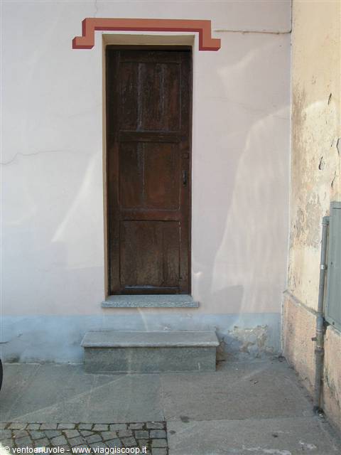 Dark wooden door with orange frame and stone step