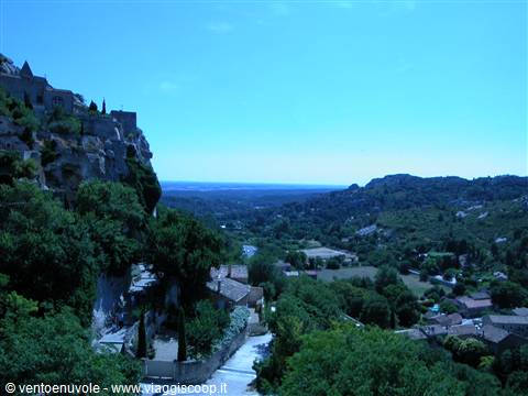Les Baux-de-Provence, stone houses perched on the cliff above green valley