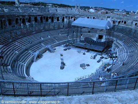 Roman amphitheater in Arles, stone tiers and stage under grey canopy