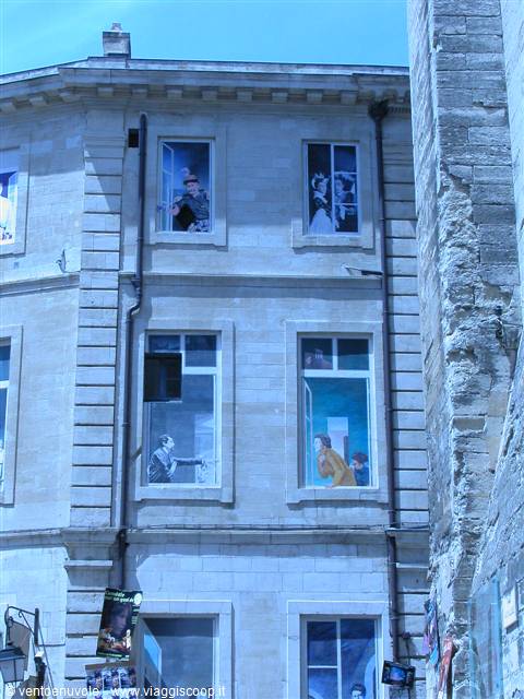 Light stone facade with painted trompe-l'oeil windows and figures