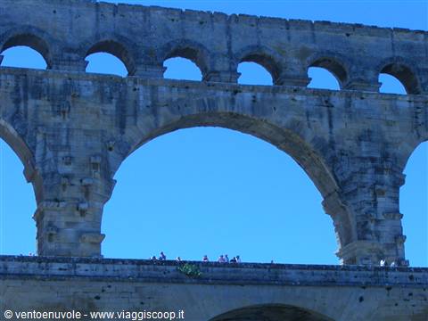 Tourists walk on the Pont du Gard terrace, ancient Roman stone aqueduct