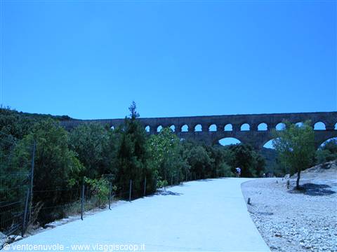 Pont du Gard, Roman arches rising over trees above white path