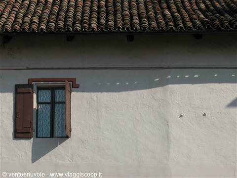 Terracotta tiles over whitewashed wall with open brown shutters