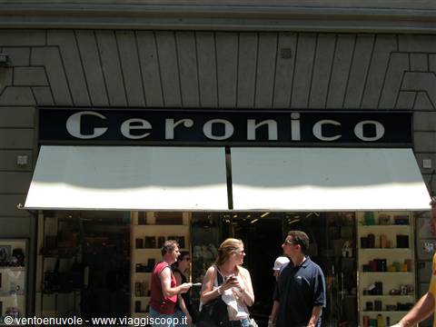 Passersby in front of the Geronico shop with black sign and white awning