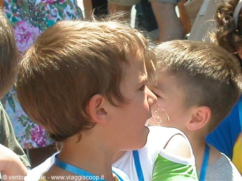 Two blond boys in a crowd on a sunny day