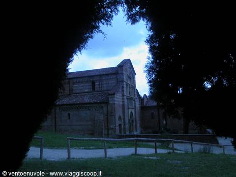 Brick church framed by dark branches at dusk
