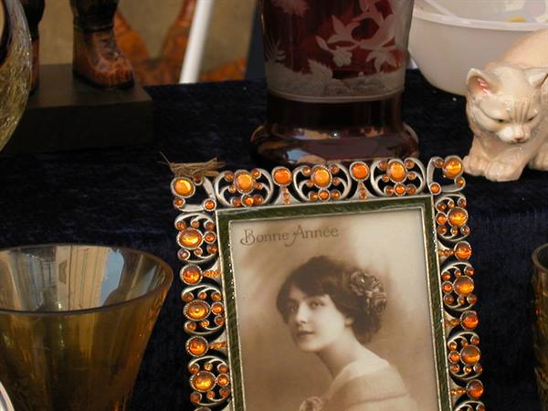 Flea market stall: jeweled orange cabochon frame with a vintage portrait