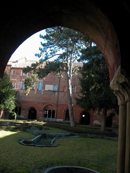 Brick cloister arch framing the courtyard garden, Staffarda Abbey