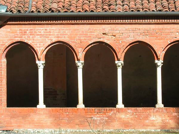 Red brick loggia with arches resting on pale stone columns