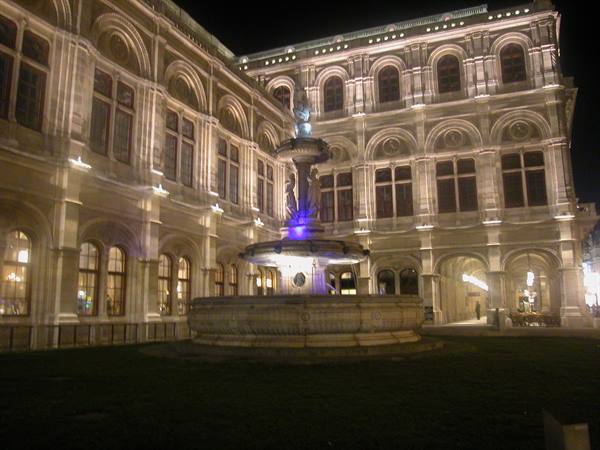 Illuminated fountain at night in front of the Vienna State Opera