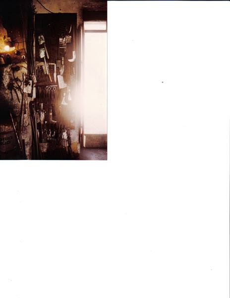 Workshop wall with hanging tools, glowing fire and bright doorway