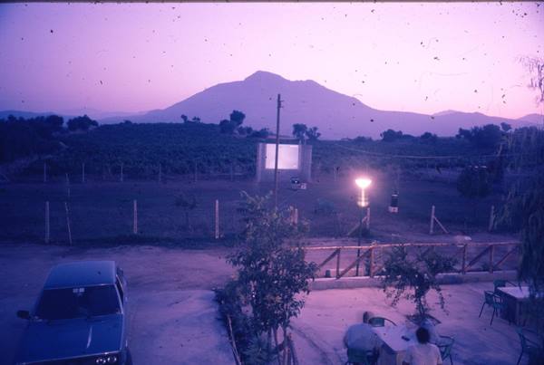 Vesuvius at dusk, car parked near an outdoor screen under purple sky