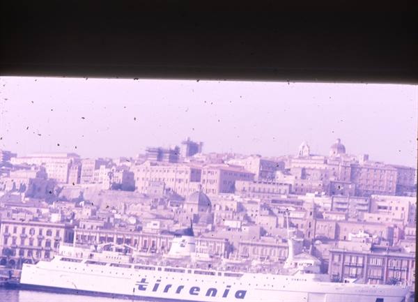 White Tirrenia ferry moored at the harbor in front of domed buildings