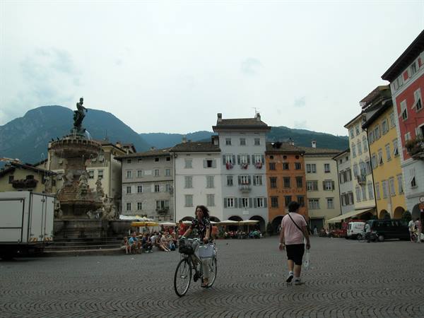 Piazza Duomo in Trento: woman cycling past the Neptune fountain