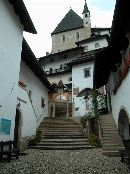 San Romedio sanctuary: stone stairway between white buildings up to the church