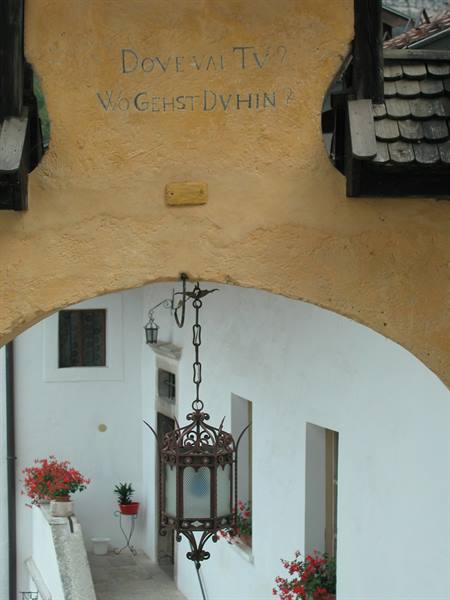 Wrought-iron lantern under a yellow arch with red flowers