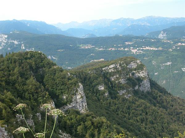 Rocky forested peaks above a village in the green valley