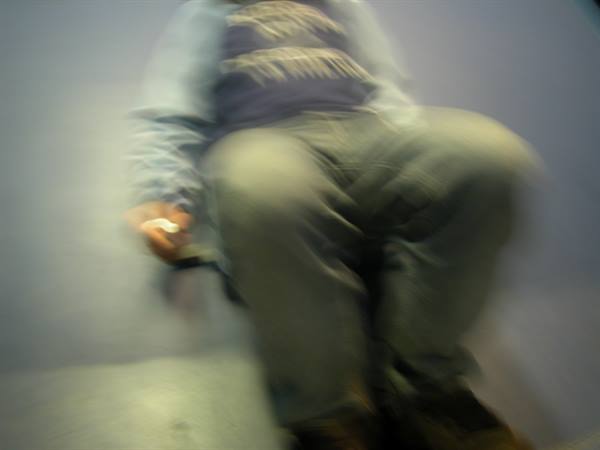 Blurred person in blue hoodie and jeans against purple background