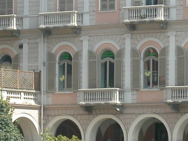 Building facade with arched arcades, stone balconies and shuttered windows