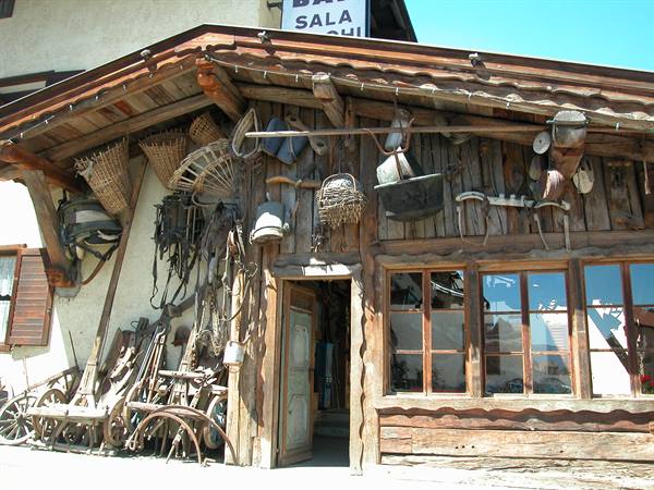 Wooden alpine chalet facade with old farming tools hanging outside