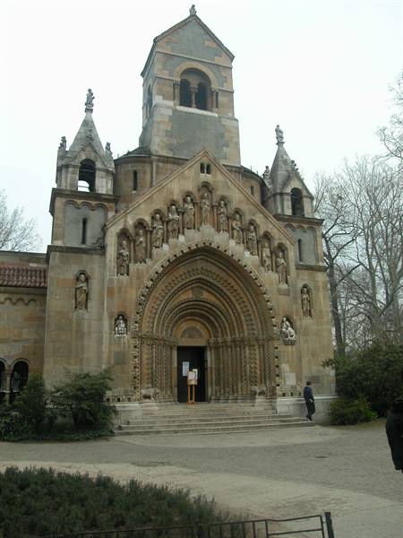Jaki Chapel in Budapest, stone facade with carved saint statues under grey sky