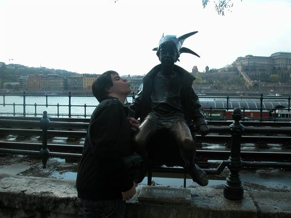 Boy kissing the bronze Little Princess statue by the Danube, Budapest