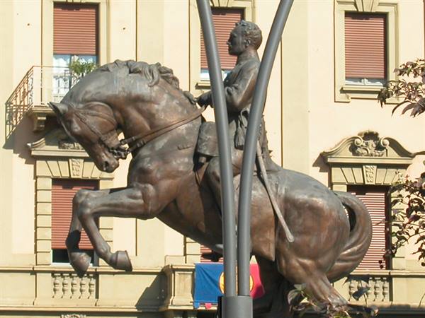 Bronze equestrian statue of Garibaldi in front of a building with flag