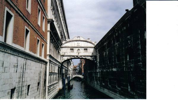 Bridge of Sighs in Venice, white stone arch over canal with gondola