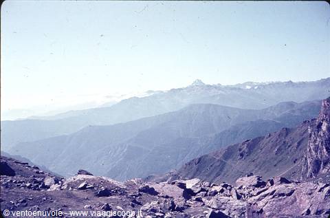 Snow-capped peaks and misty rocky ridges under a blue sky